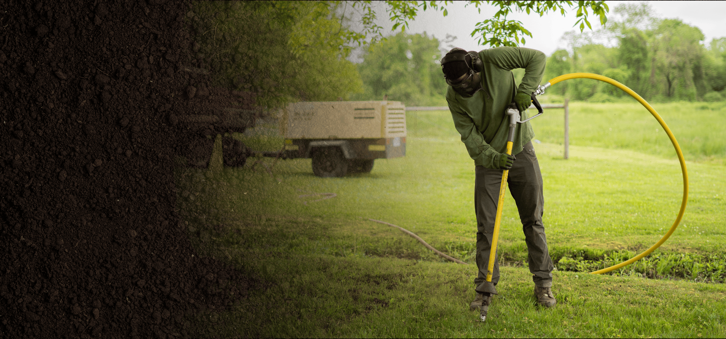 Person using an AirSpade in a grassy area with an air compressor in the background