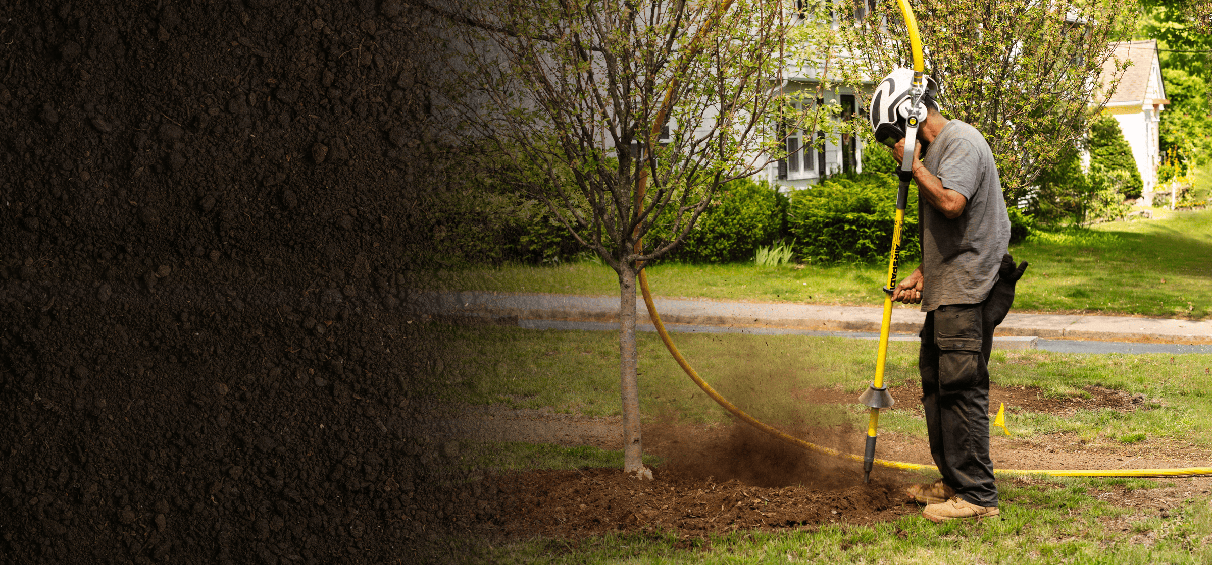 Person using an AirSpade to dig around a tree in a garden