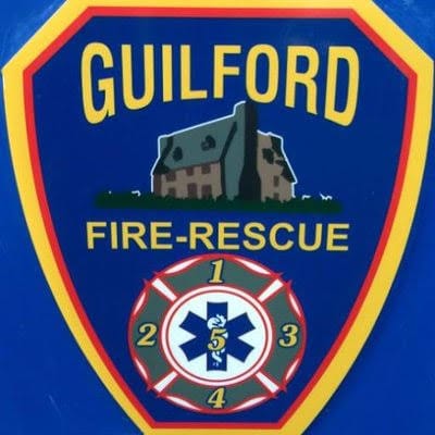 Guilford Fire-Rescue logo with a blue background, yellow text, and a house illustration.